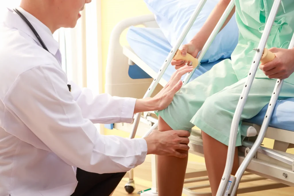 An orthopaedic specialist assessing a woman’s knee.